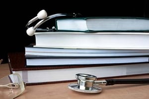 Stacks of medical books and a stethoscope